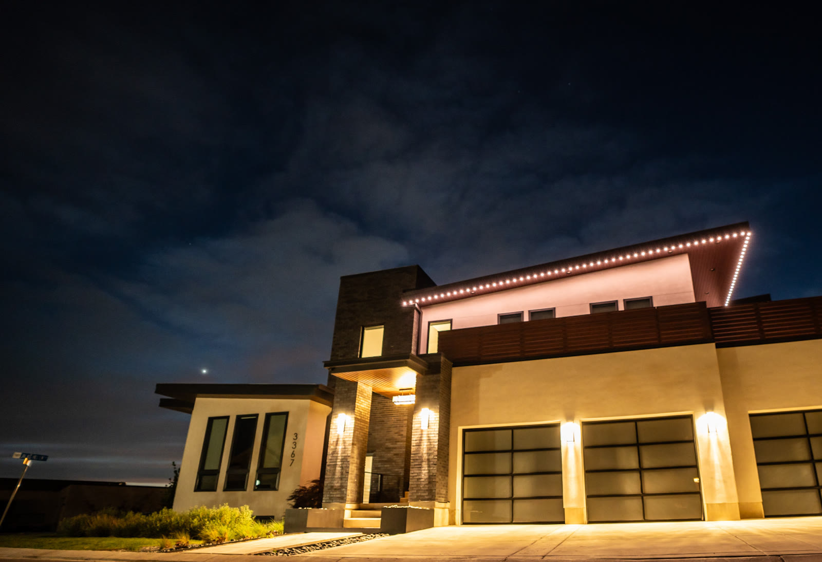 Permanent outdoor lights in warm-white architectural accent on a modern Fresno home